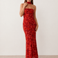 Woman wearing the Diana satin strapless maxi dress featuring a square neckline, scarf-style choker tie, open back with draped detail, and a floor-length fitted silhouette in a smooth satin finish.