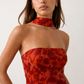 Woman wearing the Diana satin strapless maxi dress featuring a square neckline, scarf-style choker tie, open back with draped detail, and a floor-length fitted silhouette in a smooth satin finish.