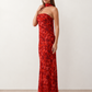 Woman wearing the Diana satin strapless maxi dress featuring a square neckline, scarf-style choker tie, open back with draped detail, and a floor-length fitted silhouette in a smooth satin finish.