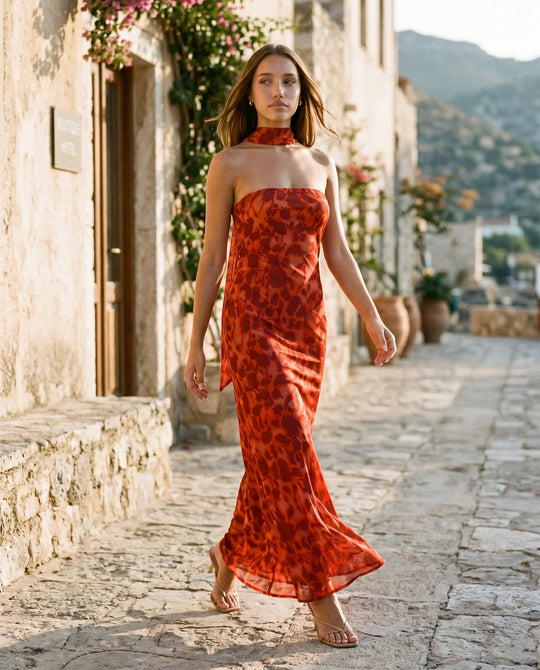 Woman wearing the Diana satin strapless maxi dress featuring a square neckline, scarf-style choker tie, open back with draped detail, and a floor-length fitted silhouette in a smooth satin finish.