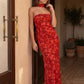 Woman wearing the Diana satin strapless maxi dress featuring a square neckline, scarf-style choker tie, open back with draped detail, and a floor-length fitted silhouette in a smooth satin finish.