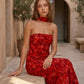 Woman wearing the Diana satin strapless maxi dress featuring a square neckline, scarf-style choker tie, open back with draped detail, and a floor-length fitted silhouette in a smooth satin finish.