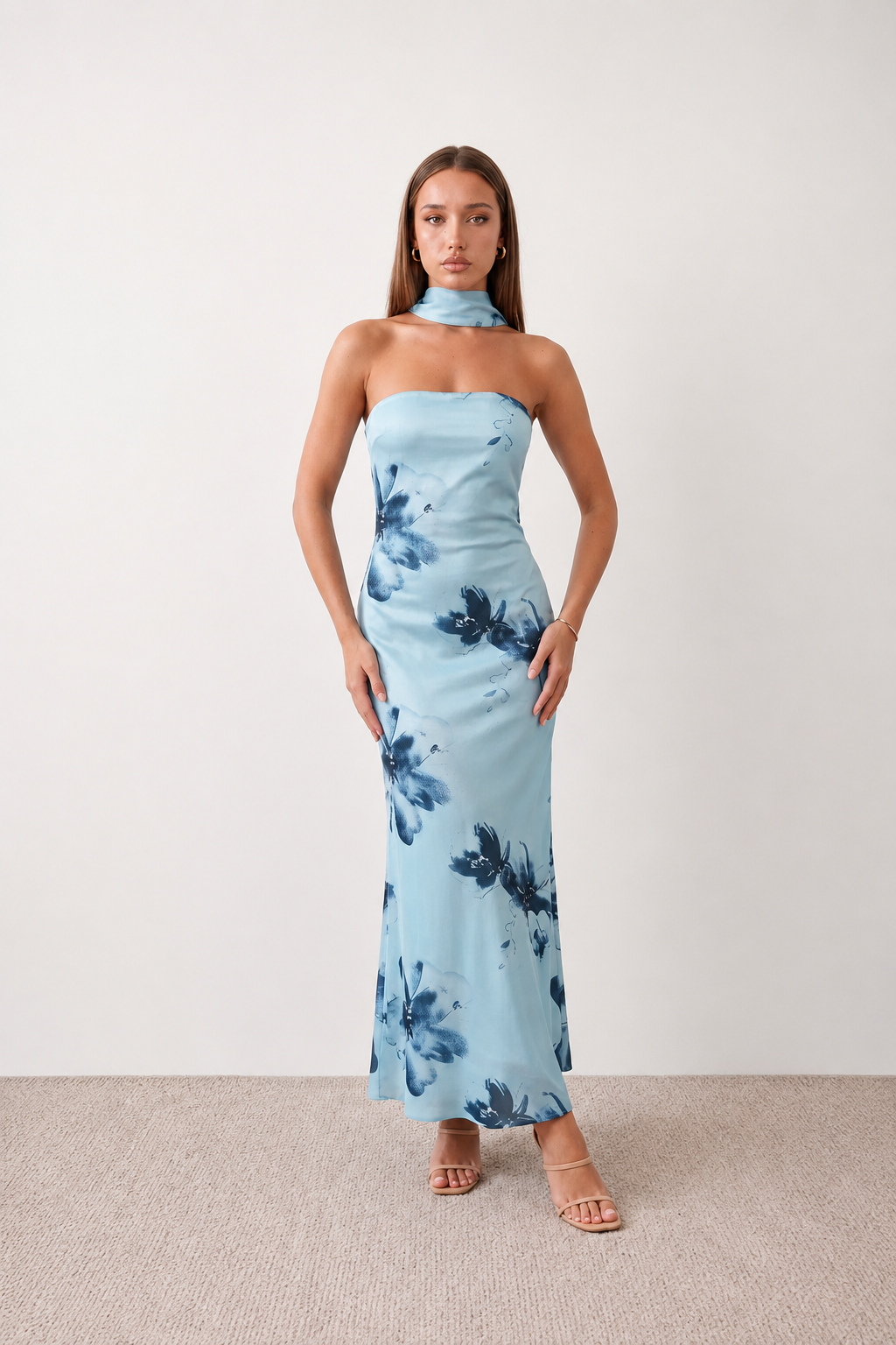 Woman wearing the Diana satin strapless maxi dress featuring a square neckline, scarf-style choker tie, open back with draped detail, and a floor-length fitted silhouette in a smooth satin finish.