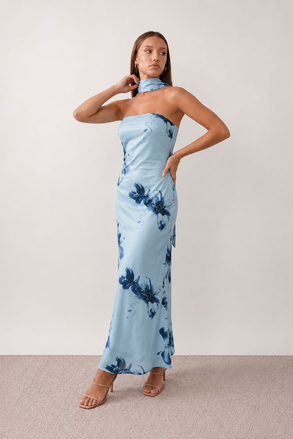 Woman wearing the Diana satin strapless maxi dress featuring a square neckline, scarf-style choker tie, open back with draped detail, and a floor-length fitted silhouette in a smooth satin finish.