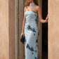 Woman wearing the Diana satin strapless maxi dress featuring a square neckline, scarf-style choker tie, open back with draped detail, and a floor-length fitted silhouette in a smooth satin finish.