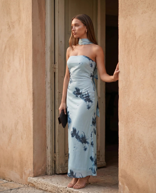 Woman wearing the Diana satin strapless maxi dress featuring a square neckline, scarf-style choker tie, open back with draped detail, and a floor-length fitted silhouette in a smooth satin finish.