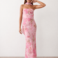 Woman wearing the Diana satin strapless maxi dress featuring a square neckline, scarf-style choker tie, open back with draped detail, and a floor-length fitted silhouette in a smooth satin finish.
