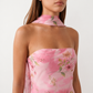 Woman wearing the Diana satin strapless maxi dress featuring a square neckline, scarf-style choker tie, open back with draped detail, and a floor-length fitted silhouette in a smooth satin finish.