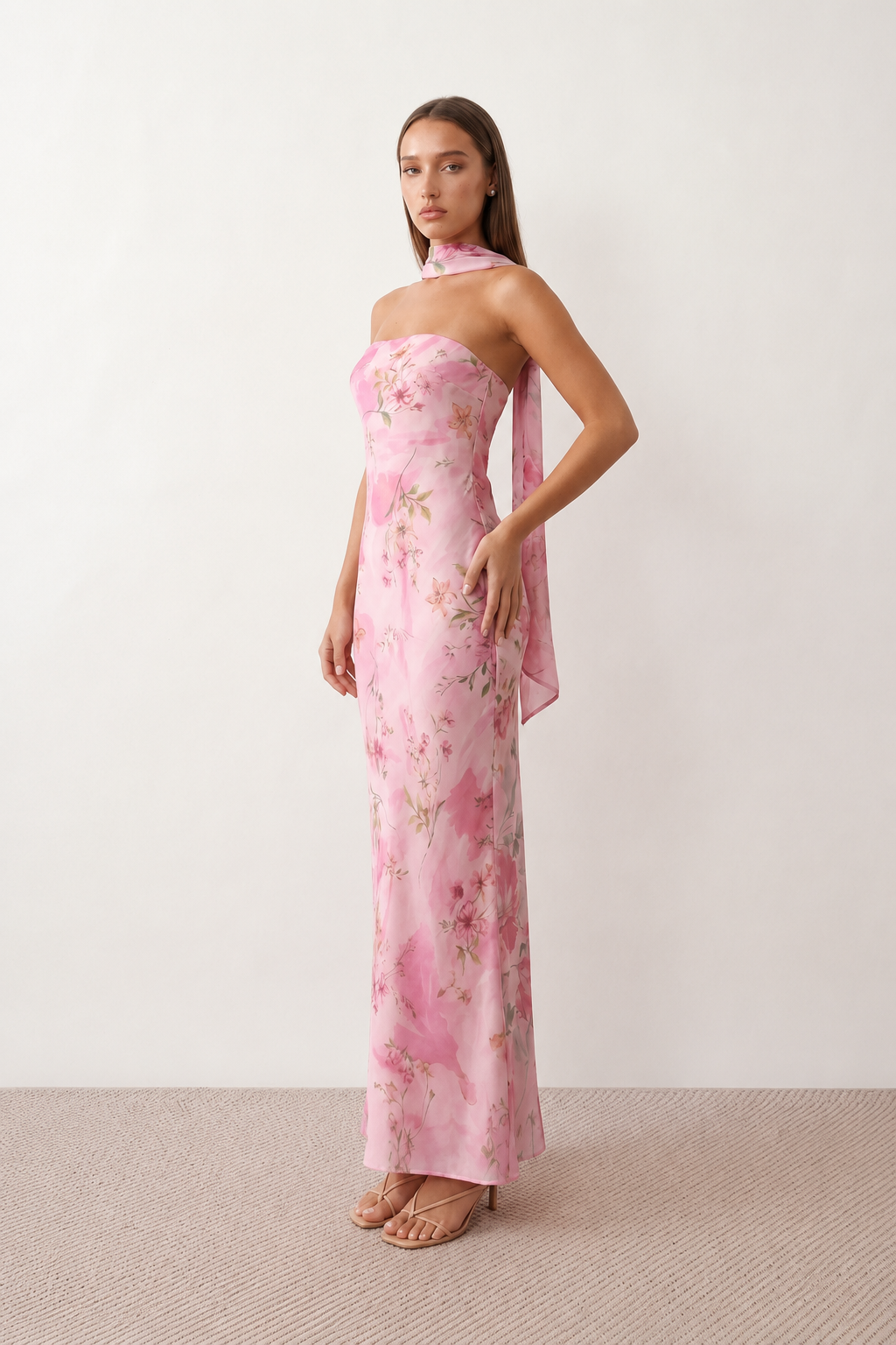 Woman wearing the Diana satin strapless maxi dress featuring a square neckline, scarf-style choker tie, open back with draped detail, and a floor-length fitted silhouette in a smooth satin finish.