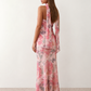 Woman wearing the Diana satin strapless maxi dress featuring a square neckline, scarf-style choker tie, open back with draped detail, and a floor-length fitted silhouette in a smooth satin finish.