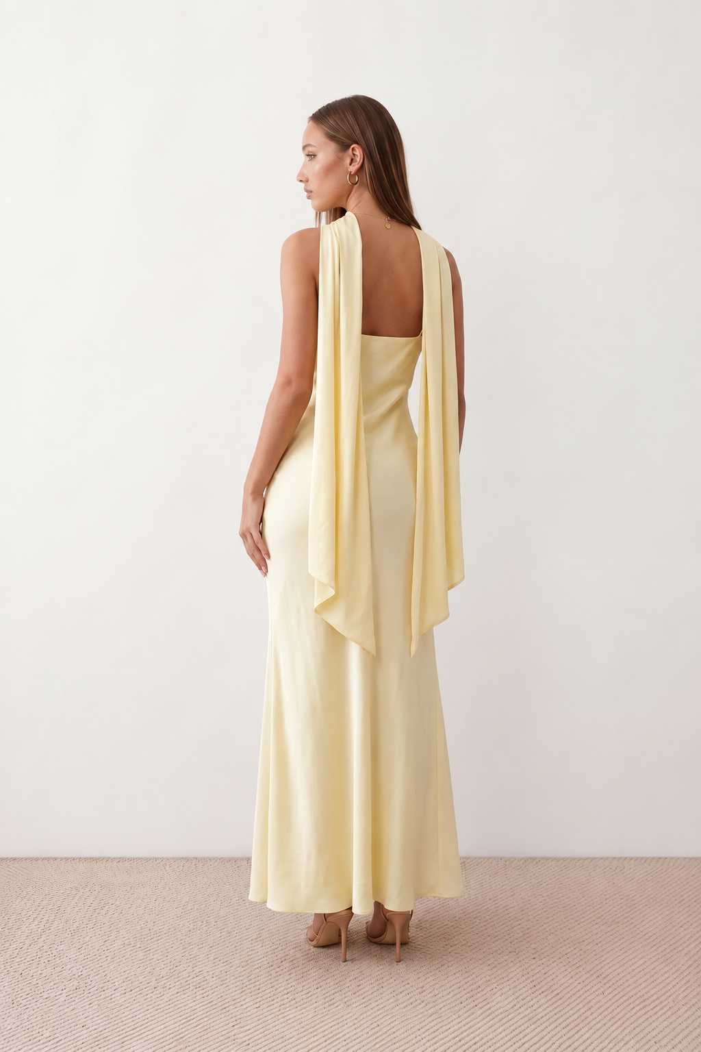 Woman wearing the Diana satin strapless maxi dress featuring a square neckline, scarf-style choker tie, open back with draped detail, and a floor-length fitted silhouette in a smooth satin finish.