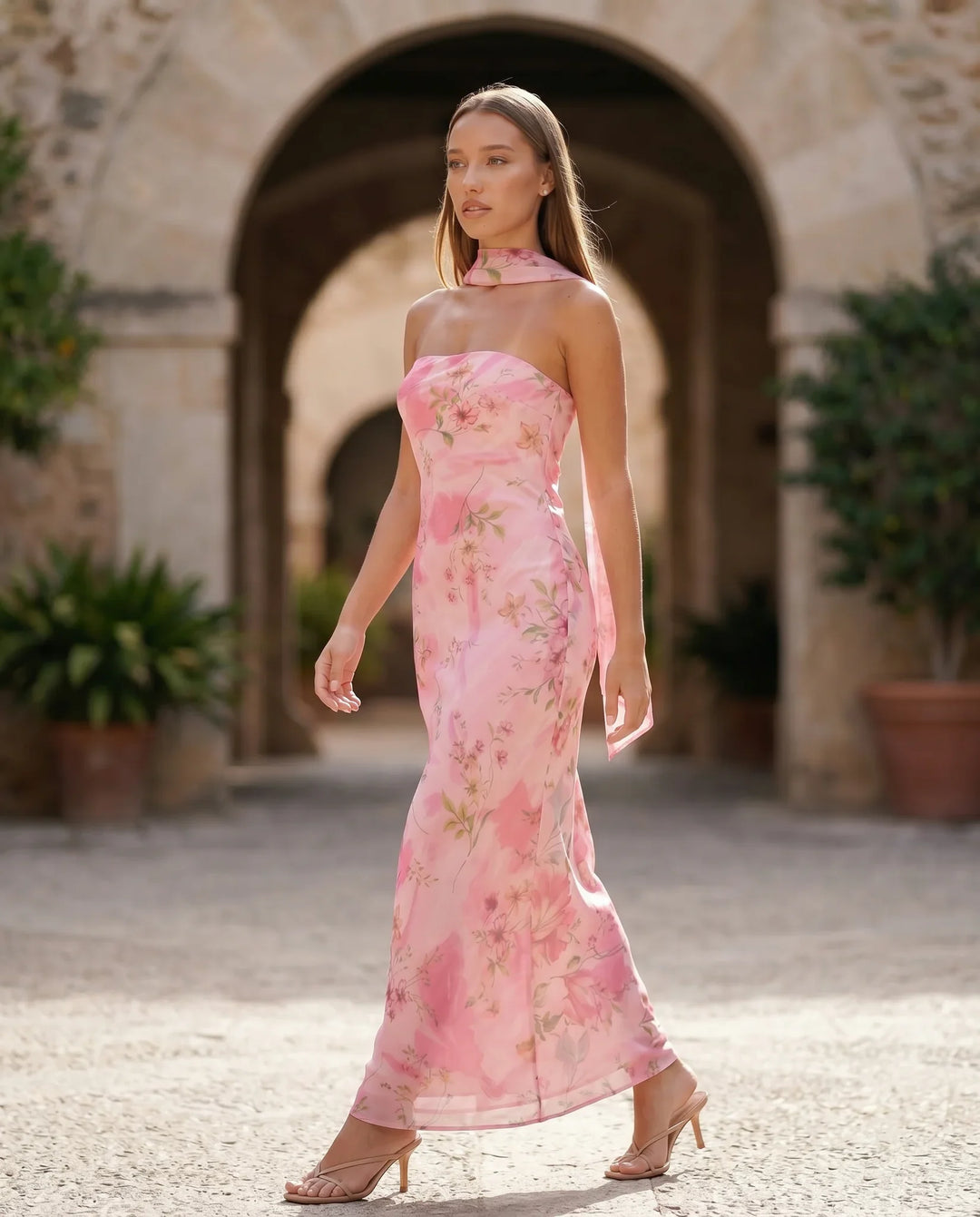 Woman wearing the Diana satin strapless maxi dress featuring a square neckline, scarf-style choker tie, open back with draped detail, and a floor-length fitted silhouette in a smooth satin finish.