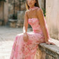 Woman wearing the Diana satin strapless maxi dress featuring a square neckline, scarf-style choker tie, open back with draped detail, and a floor-length fitted silhouette in a smooth satin finish.