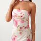 Woman wearing the Diana satin strapless maxi dress featuring a square neckline, scarf-style choker tie, open back with draped detail, and a floor-length fitted silhouette in a smooth satin finish.