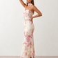 Woman wearing the Diana satin strapless maxi dress featuring a square neckline, scarf-style choker tie, open back with draped detail, and a floor-length fitted silhouette in a smooth satin finish.