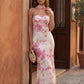 Woman wearing the Diana satin strapless maxi dress featuring a square neckline, scarf-style choker tie, open back with draped detail, and a floor-length fitted silhouette in a smooth satin finish.