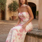 Woman wearing the Diana satin strapless maxi dress featuring a square neckline, scarf-style choker tie, open back with draped detail, and a floor-length fitted silhouette in a smooth satin finish.