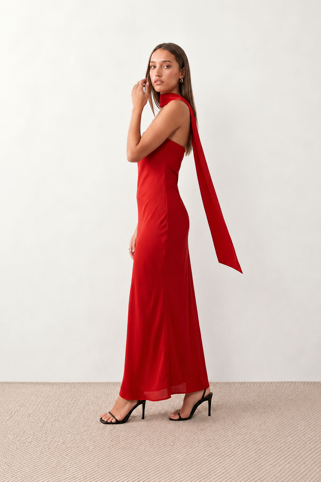 Woman wearing the Diana satin strapless maxi dress featuring a square neckline, scarf-style choker tie, open back with draped detail, and a floor-length fitted silhouette in a smooth satin finish.