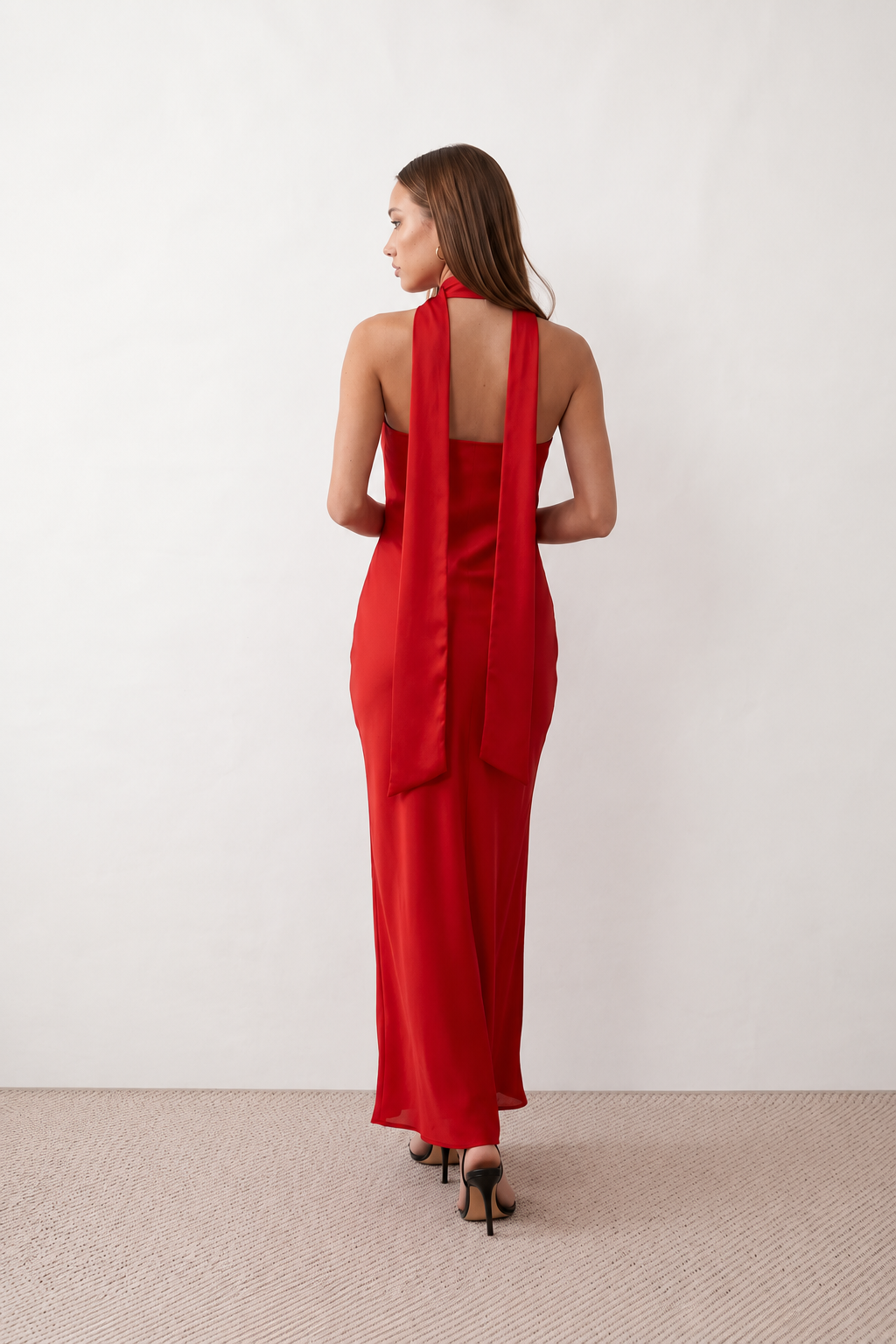 Woman wearing the Diana satin strapless maxi dress featuring a square neckline, scarf-style choker tie, open back with draped detail, and a floor-length fitted silhouette in a smooth satin finish.