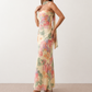 Woman wearing the Diana satin strapless maxi dress featuring a square neckline, scarf-style choker tie, open back with draped detail, and a floor-length fitted silhouette in a smooth satin finish.