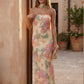 Woman wearing the Diana satin strapless maxi dress featuring a square neckline, scarf-style choker tie, open back with draped detail, and a floor-length fitted silhouette in a smooth satin finish.