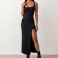 Woman wearing the Skye Open Back Fitted Maxi Dress featuring a square neckline, wide shoulder straps, ruched bodycon silhouette, open back with a smocked panel and tie-bow fastening, thigh-high side split, and floor-length maxi design, perfect for weddings, cocktail parties and formal occasions.