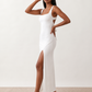 Woman wearing the Skye Open Back Fitted Maxi Dress featuring a square neckline, wide shoulder straps, ruched bodycon silhouette, open back with a smocked panel and tie-bow fastening, thigh-high side split, and floor-length maxi design, perfect for weddings, cocktail parties and formal occasions.