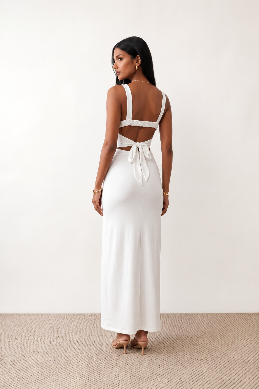 Woman wearing the Skye Open Back Fitted Maxi Dress featuring a square neckline, wide shoulder straps, ruched bodycon silhouette, open back with a smocked panel and tie-bow fastening, thigh-high side split, and floor-length maxi design, perfect for weddings, cocktail parties and formal occasions.