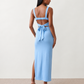 Woman wearing the Skye Open Back Fitted Maxi Dress featuring a square neckline, wide shoulder straps, ruched bodycon silhouette, open back with a smocked panel and tie-bow fastening, thigh-high side split, and floor-length maxi design, perfect for weddings, cocktail parties and formal occasions.