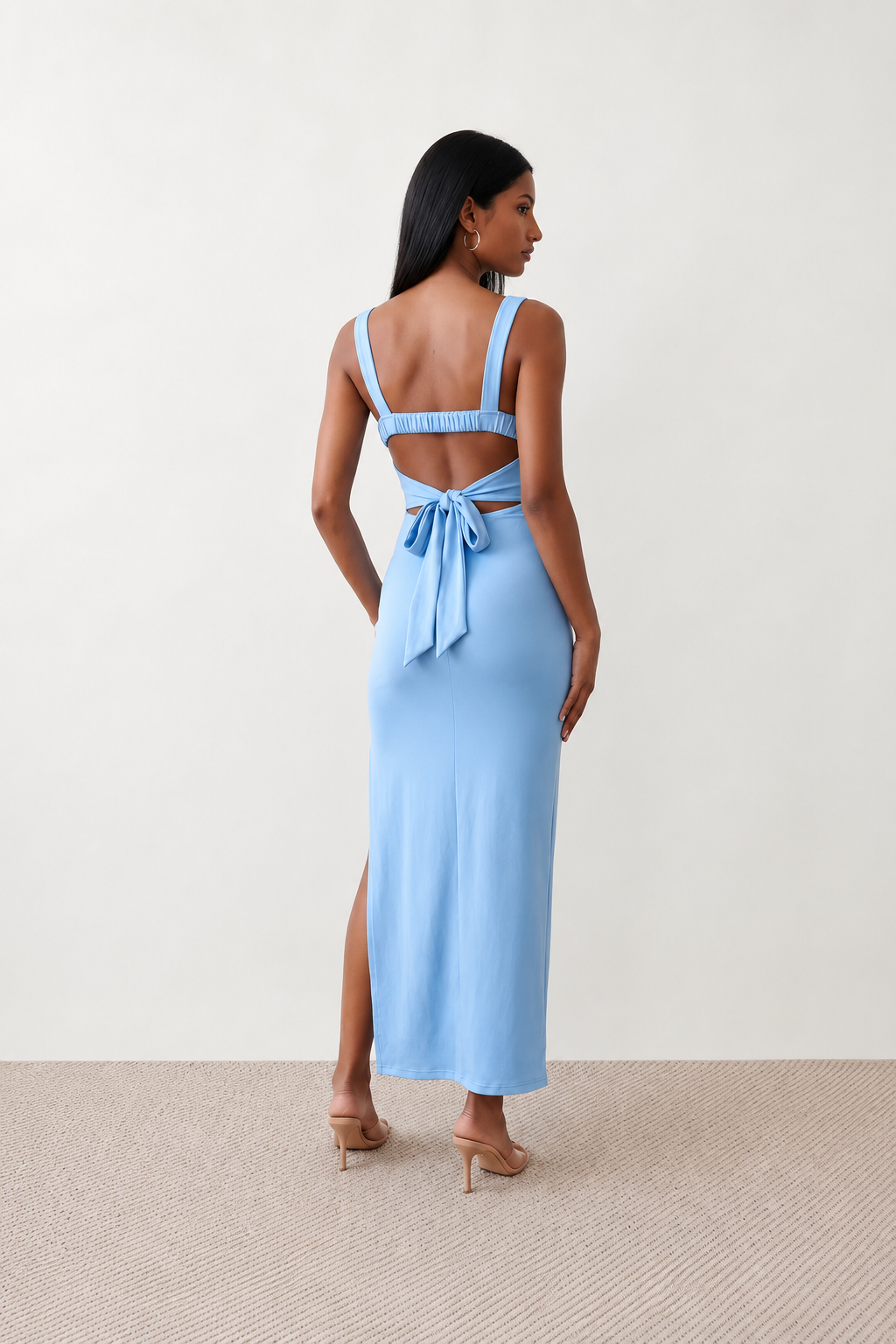 Woman wearing the Skye Open Back Fitted Maxi Dress featuring a square neckline, wide shoulder straps, ruched bodycon silhouette, open back with a smocked panel and tie-bow fastening, thigh-high side split, and floor-length maxi design, perfect for weddings, cocktail parties and formal occasions.