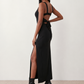 Woman wearing the Skye Open Back Fitted Maxi Dress featuring a square neckline, wide shoulder straps, ruched bodycon silhouette, open back with a smocked panel and tie-bow fastening, thigh-high side split, and floor-length maxi design, perfect for weddings, cocktail parties and formal occasions.