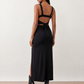 Woman wearing the Skye Open Back Fitted Maxi Dress featuring a square neckline, wide shoulder straps, ruched bodycon silhouette, open back with a smocked panel and tie-bow fastening, thigh-high side split, and floor-length maxi design, perfect for weddings, cocktail parties and formal occasions.