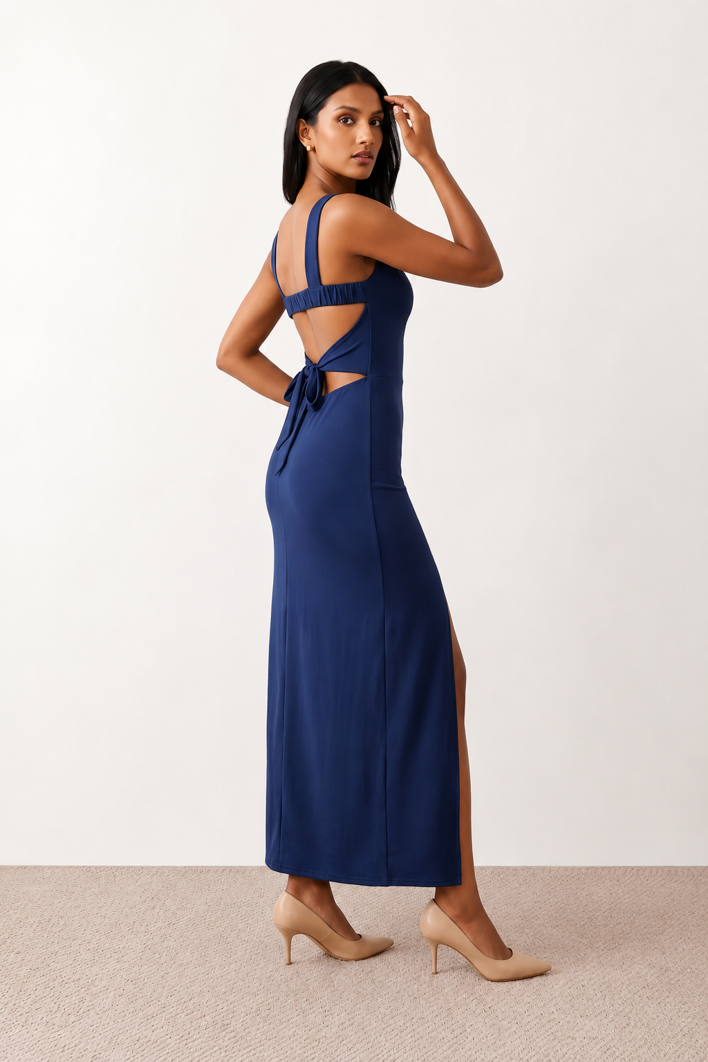 Woman wearing the Skye Open Back Fitted Maxi Dress featuring a square neckline, wide shoulder straps, ruched bodycon silhouette, open back with a smocked panel and tie-bow fastening, thigh-high side split, and floor-length maxi design, perfect for weddings, cocktail parties and formal occasions.