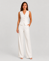 Woman wearing a sleeveless tailored waistcoat with high-waisted wide-leg trousers in a coordinated two-piece set, featuring a relaxed elegant silhouette and modern tailoring.