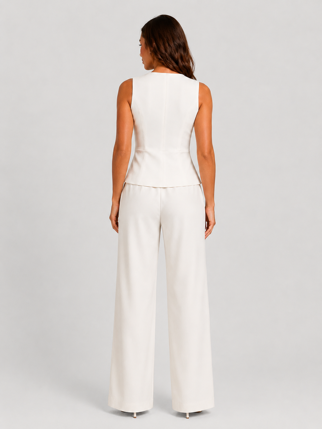 Woman wearing a sleeveless tailored waistcoat with high-waisted wide-leg trousers in a coordinated two-piece set, featuring a relaxed elegant silhouette and modern tailoring.