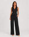 Woman wearing a sleeveless tailored waistcoat with high-waisted wide-leg trousers in a coordinated two-piece set, featuring a relaxed elegant silhouette and modern tailoring.
