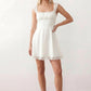 Women's Soraia Lace Lace-Up Mini Dress featuring elegant floral lace, a square neckline with a ruched bust, scalloped cap sleeves, a corset-style lace-up back, and a flattering A-line mini skirt finished with a scalloped lace hem, perfect for weddings, race days, garden parties and special occasions.