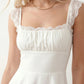 Women's Soraia Lace Lace-Up Mini Dress featuring elegant floral lace, a square neckline with a ruched bust, scalloped cap sleeves, a corset-style lace-up back, and a flattering A-line mini skirt finished with a scalloped lace hem, perfect for weddings, race days, garden parties and special occasions.