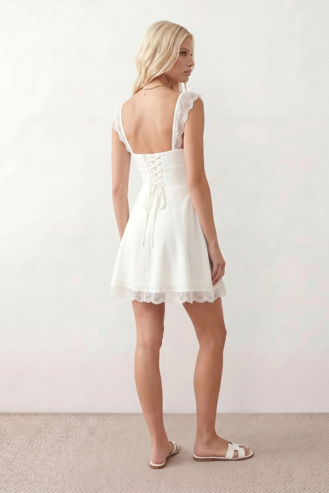 Women's Soraia Lace Lace-Up Mini Dress featuring elegant floral lace, a square neckline with a ruched bust, scalloped cap sleeves, a corset-style lace-up back, and a flattering A-line mini skirt finished with a scalloped lace hem, perfect for weddings, race days, garden parties and special occasions.