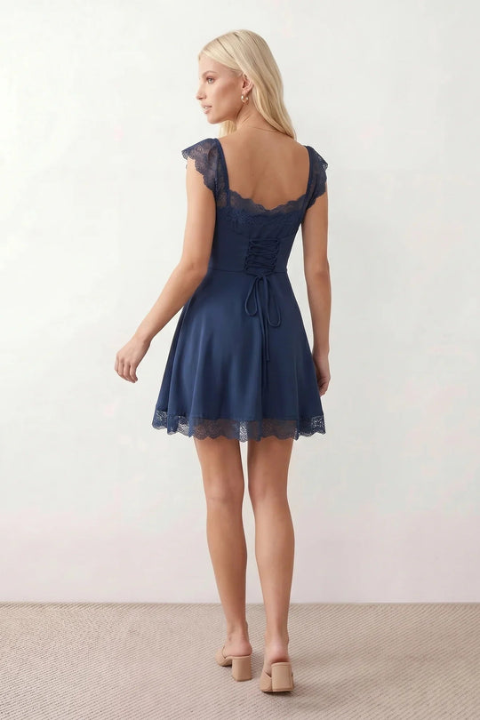 Women's Soraia Lace Lace-Up Mini Dress featuring elegant floral lace, a square neckline with a ruched bust, scalloped cap sleeves, a corset-style lace-up back, and a flattering A-line mini skirt finished with a scalloped lace hem, perfect for weddings, race days, garden parties and special occasions.