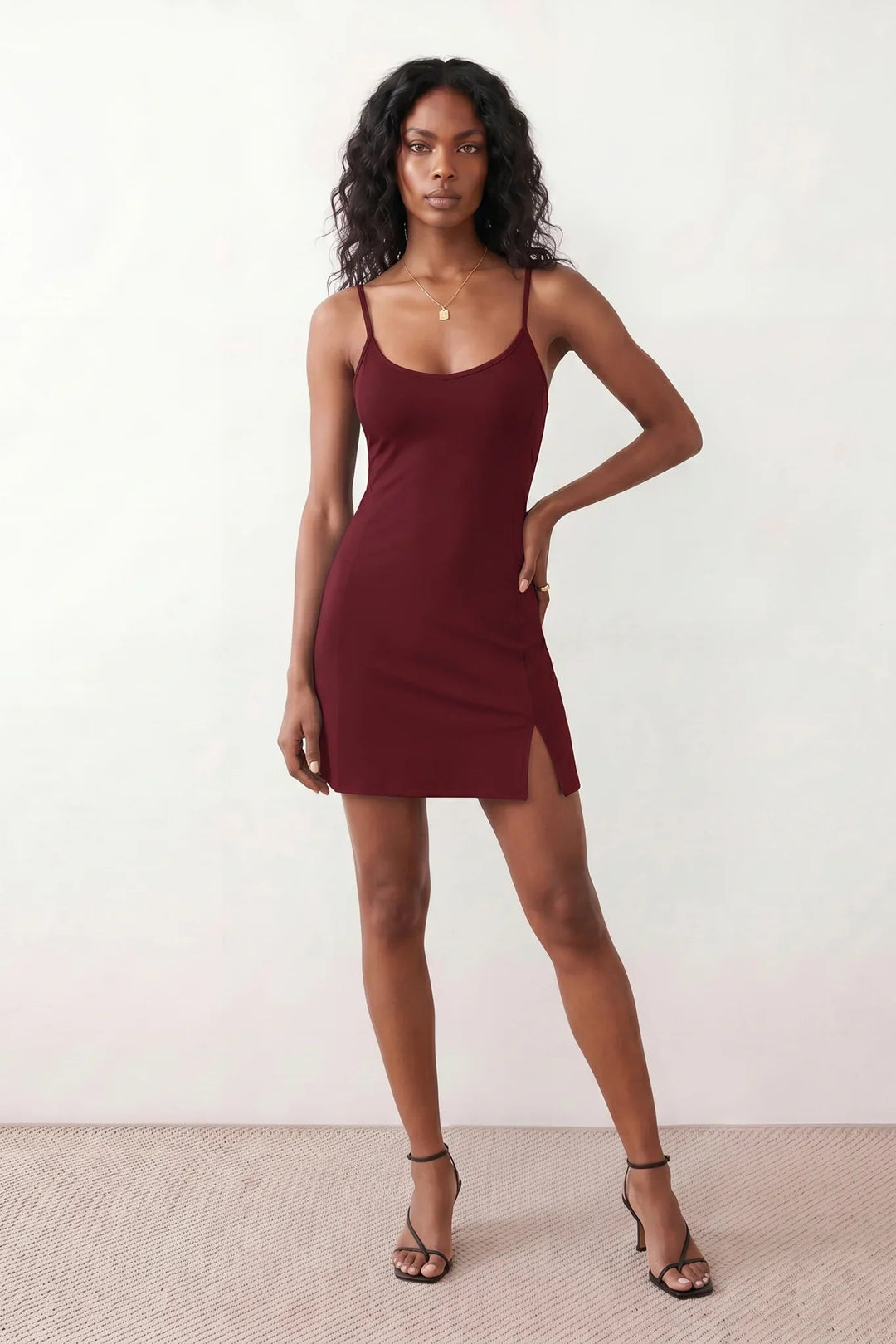 Woman wearing the spaghetti strap low back fitted mini dress featuring adjustable straps, a figure-hugging sheath silhouette, elegant low open back, side slit, and mini-length hem, perfect for parties, weddings, and evening occasions.