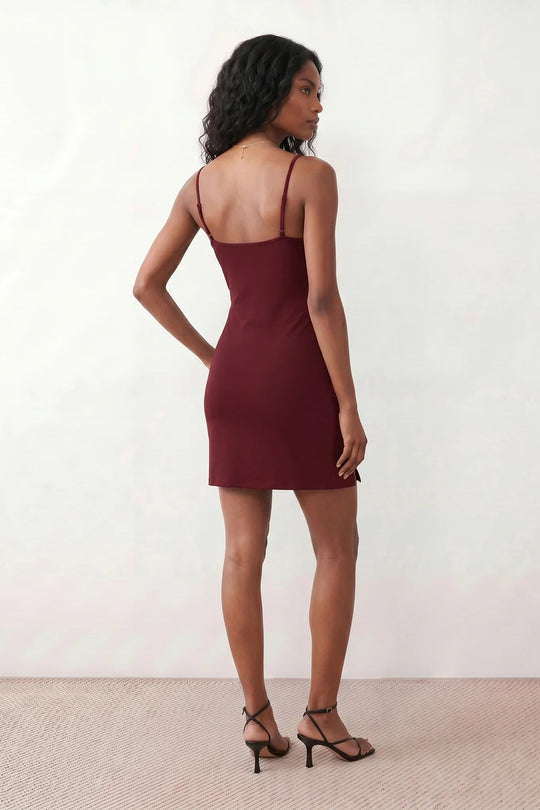 Woman wearing the spaghetti strap low back fitted mini dress featuring adjustable straps, a figure-hugging sheath silhouette, elegant low open back, side slit, and mini-length hem, perfect for parties, weddings, and evening occasions.