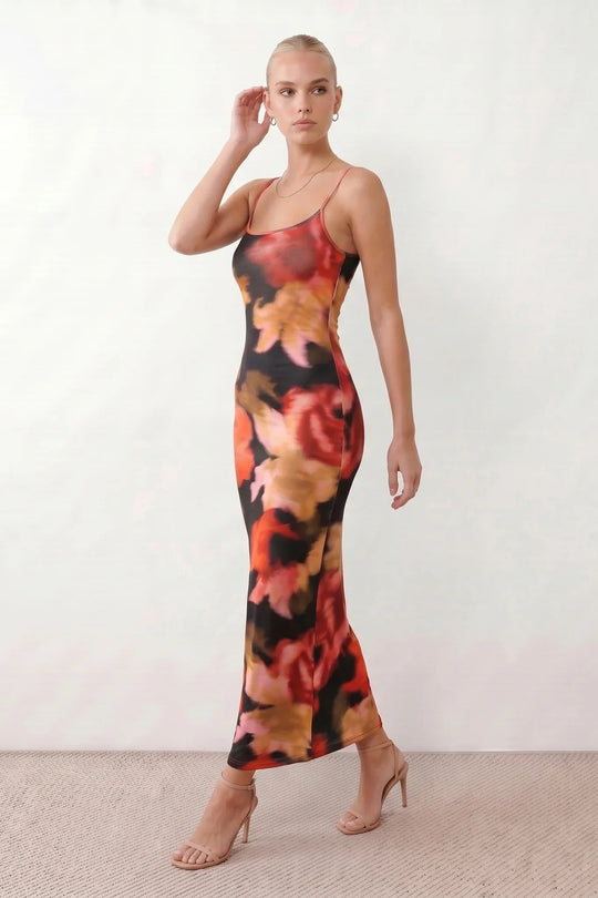 Women's spaghetti strap floral maxi dress with a fitted sheath silhouette, round neckline, adjustable straps, and elegant low open back in a red and black floral print, perfect for weddings and special occasions.