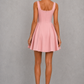 Women’s square neck pleated mini dress featuring delicate shoulder straps, a fitted bodice, and a flowing A-line skirt in soft pale pink for parties and special occasions.