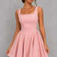 Women’s square neck pleated mini dress featuring delicate shoulder straps, a fitted bodice, and a flowing A-line skirt in soft pale pink for parties and special occasions.