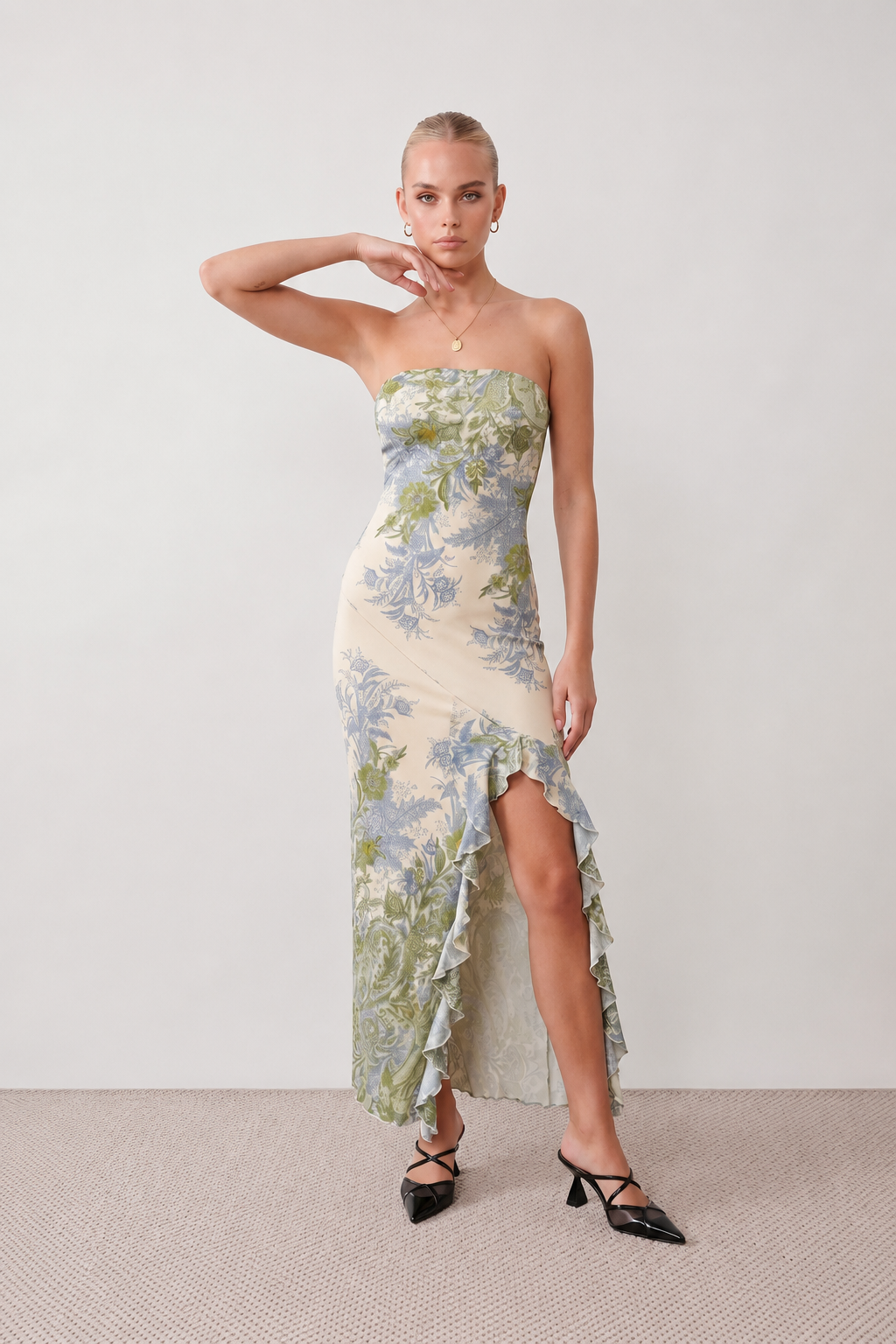 Woman wearing the Madelyn Strapless Floral Maxi Dress featuring a strapless square neckline, fitted bodice, botanical floral print, cascading layered ruffle front split, and flowing maxi-length skirt, ideal for weddings, race days, garden parties, and formal occasions.