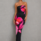 Woman wearing a strapless floral print midi dress with a fitted bodice and fit-and-flare silhouette in soft jersey fabric, ideal for wedding guests, garden parties, and special occasions.