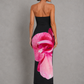 Woman wearing a strapless floral print midi dress with a fitted bodice and fit-and-flare silhouette in soft jersey fabric, ideal for wedding guests, garden parties, and special occasions.