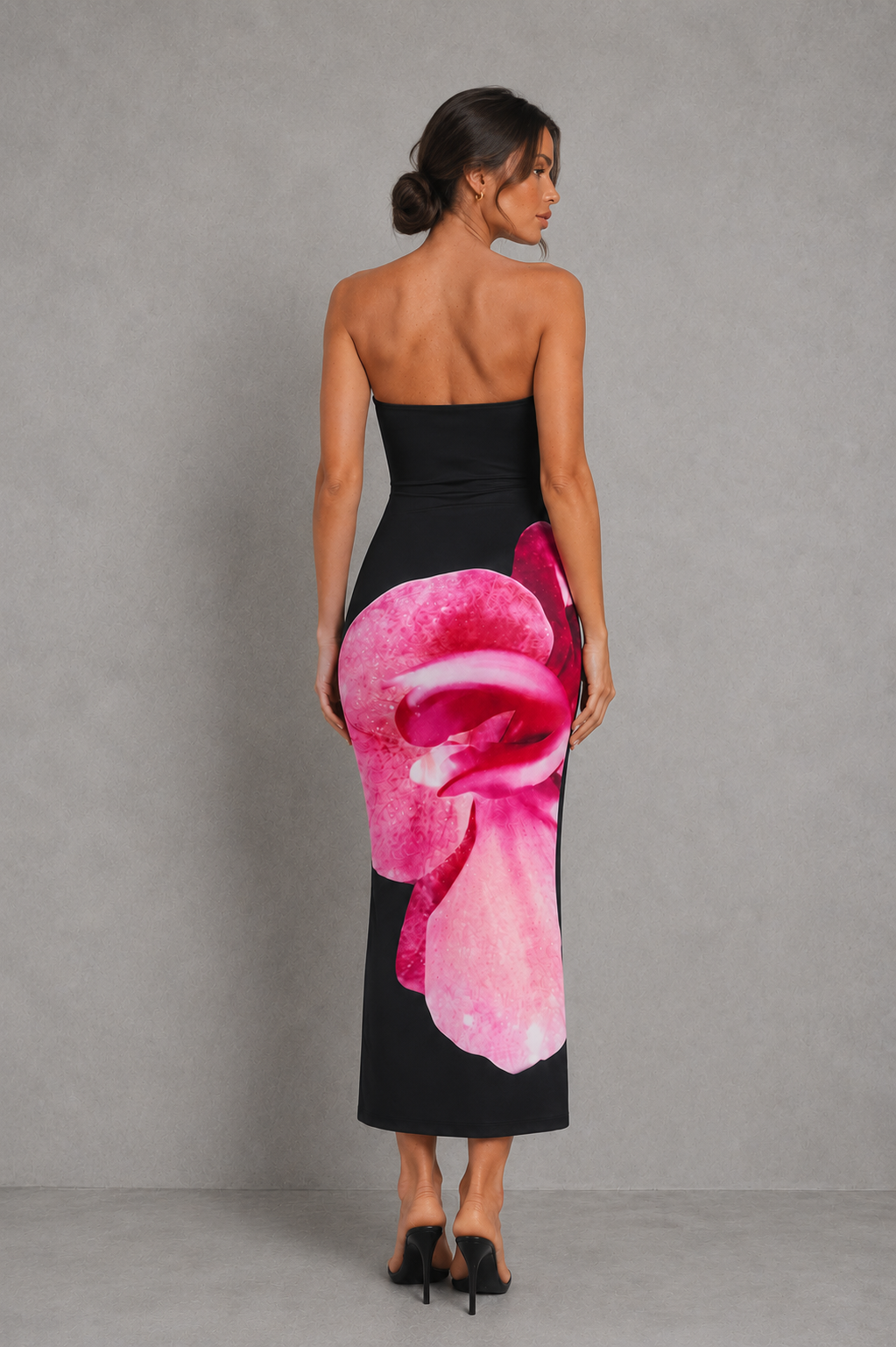 Woman wearing a strapless floral print midi dress with a fitted bodice and fit-and-flare silhouette in soft jersey fabric, ideal for wedding guests, garden parties, and special occasions.