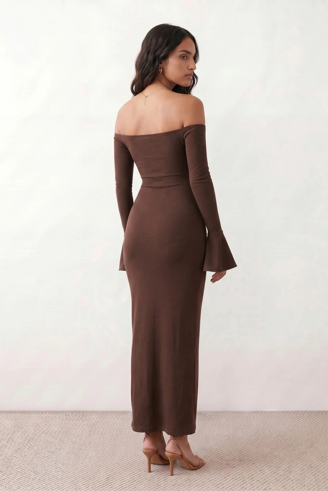 Woman wearing the strapless mermaid maxi dress with a sweetheart neckline, statement shoulder bow, matching long bell-cuff gloves, fitted silhouette and floor-length hem, ideal for weddings, black-tie events and formal occasions.